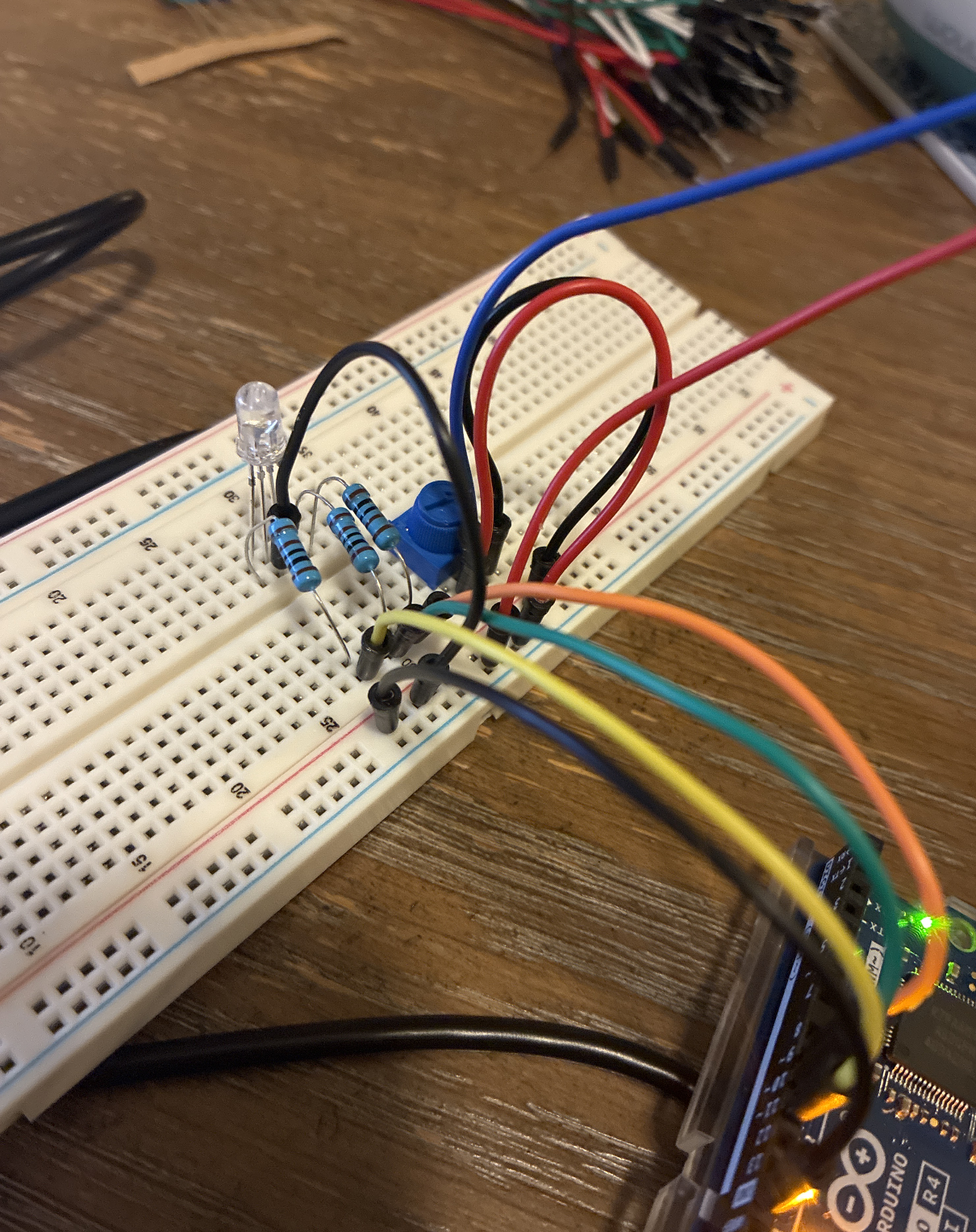 Full setup shown: breadboard, resistors, DuPont cables, potentiometer, RGB LED.
